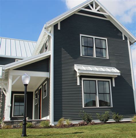 black metal roof on gray house|grey house with black awnings.